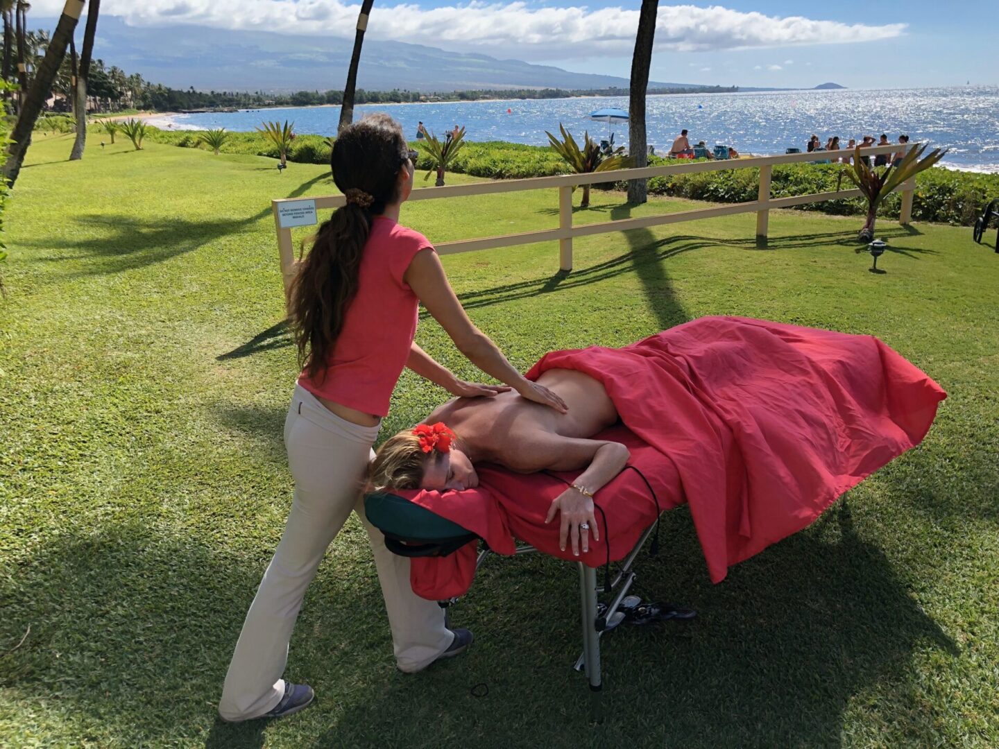 A woman is standing over a man on a bed.